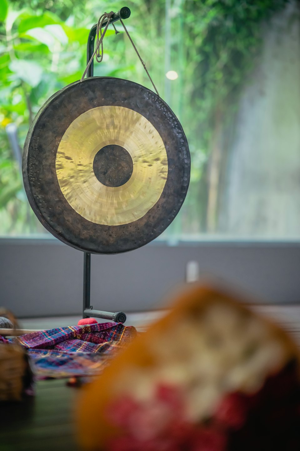 Gong di bronzo con centro dorato su un supporto.